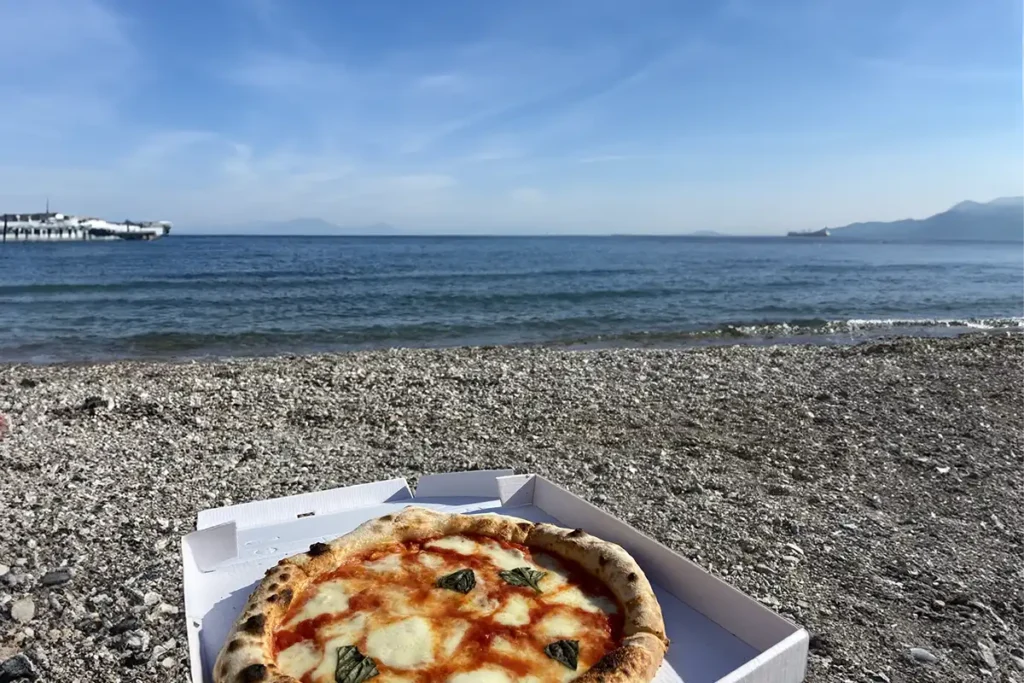 Comiendo pizza en la playa vacía de Amalfi
